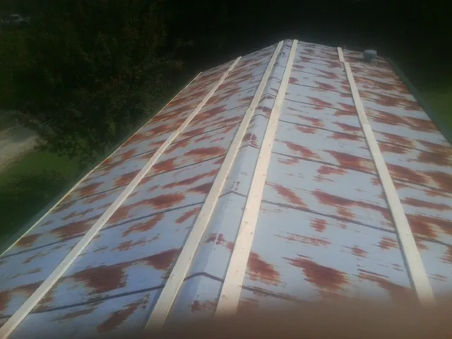 Rusted metal roof panels with new wood purlins before replacement — Storm Damage Roof Repair in Norman by Roofing Brothers