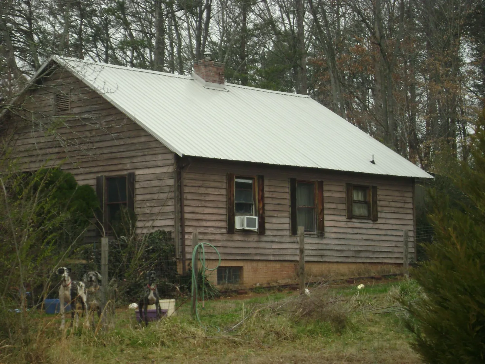 White metal roof on an old wood sided farmhouse, from a Asphalt Shingle Roof Repair job in Norman